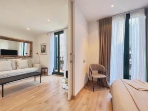バルセロナにあるStay U-nique Apartments Urquinaona IIのベッドルーム(ベッド1台、ソファ付)