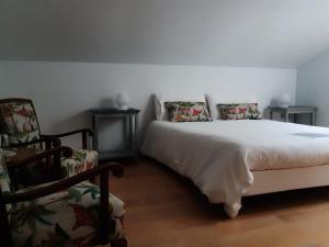 um quarto com uma cama branca e 2 cadeiras em Casa rural y B&B la Perla em Hiendelaencina