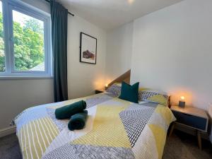 カーディフにある8 Person, 4 Bedroom Light, Warm & Modern Apartmentのベッドルーム1室(緑の枕が付くベッド1台、窓付)