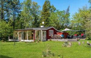 ein rotes winziges Haus in einem Hof in der Unterkunft Gorgeous Home In Asns With Kitchen in Asnæs