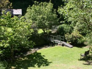 a park with a bench in the middle of a garden at Mill Cottage in Tintagel