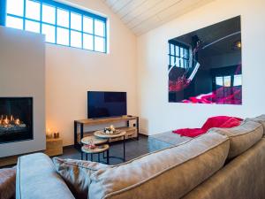 Welldone Resort / Cozy Wine في Nieuwerkerken: غرفة معيشة مع أريكة ومدفأة