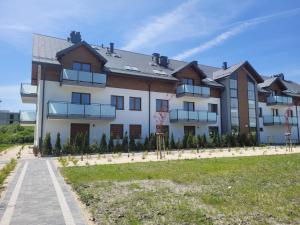 een groot wit gebouw met een basketbalveld ervoor bij Apartament Elżbieta in Busko-Zdrój