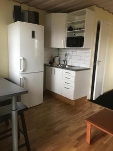 a kitchen with white cabinets and a white refrigerator at Līdumnieki in Vērgale