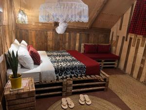 1 dormitorio con cama, sofá y zapatillas en Serengeti Villa, en Arusha