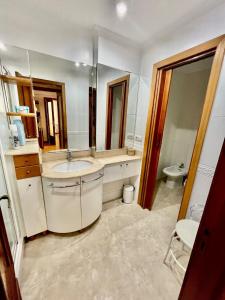 y baño con lavabo y espejo. en Agradable Apartamento en el Centro de Burgos Parking Free ATUAIRE, en Burgos