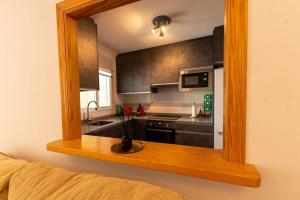 ein Spiegel mit einer Küche mit einem Waschbecken und einem Herd in der Unterkunft Casa La Marina in La Marina