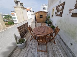 um pátio com uma mesa de madeira e cadeiras numa varanda em Apartamento da Praia com jacuzzi em Portimão
