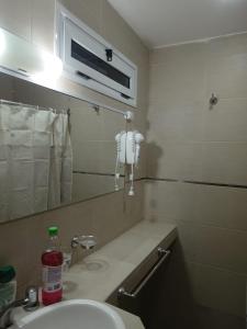 baño con lavabo y teléfono en la pared en COMPLEJO ANICETO en Godoy Cruz