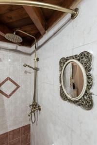 espejo en la pared del baño con ducha en Ktima Dimitrios en Naxos