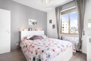 um quarto branco com uma cama com colcha floral em Casa del Sole em Lesa