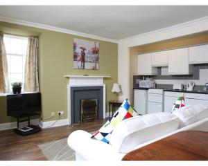 a living room with two white couches and a fireplace at Glasgow City Apartments in Glasgow