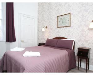 um quarto com uma cama roxa com duas toalhas em Glasgow City Apartments em Glasgow