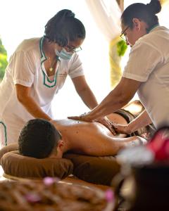 a man getting a massage from two people at Selá Nicaragua in El Gigante