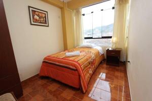 um pequeno quarto com uma cama e uma janela em Appartments in Cusco em Cusco