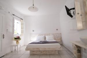 ナウサにあるPorto Naoussaの白いベッドルーム(ベッド1台、シンク付)