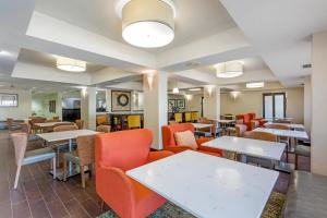 una sala da pranzo con tavoli, sedie e una tavola di Comfort Inn Plano-Dallas a Plano