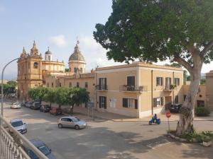 a street with cars parked in front of a building at Le Casette in Santa Flavia