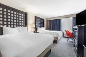 a hotel room with two beds and a television at Comfort Inn Plano-Dallas in Plano