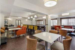 a restaurant with tables and chairs and a bar at Comfort Inn Plano-Dallas in Plano