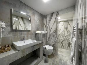 uma casa de banho com um lavatório e um WC em Hotel Mariko Inn em Roman