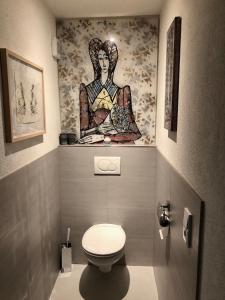 een badkamer met een toilet en een schilderij aan de muur bij Exklusive Ferienwohnung in Außervillgraten
