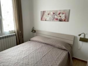 1 dormitorio con 1 cama y una foto en la pared en Bon Bon Apartment, en Mazara del Vallo
