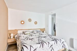 a bedroom with a bed with a black and white comforter at Appart' Cocooning & Double Balneotherapy - Cognac Center in Cognac