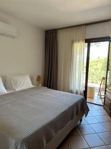 sypialnia z łóżkiem i dużym oknem w obiekcie Casa Bruno w mieście Sivota
