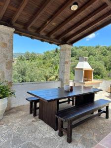 stół piknikowy i ławka na patio w obiekcie Casa Bruno w mieście Sivota