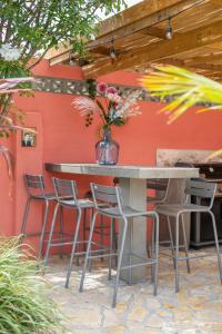 a table and chairs in front of a red wall at Happy Curoase in Willemstad