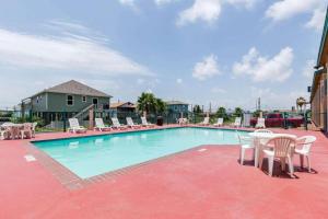 una gran piscina con sillas y una mesa en The Residency Inn, en Galveston