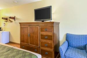1 dormitorio con TV en la parte superior de un tocador en The Residency Inn, en Galveston
