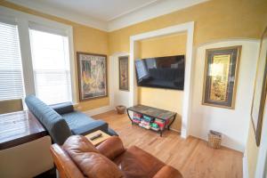 een woonkamer met een bank en een flatscreen-tv bij City Villa Sleeps 10-20 Free TV & Parking in Chicago