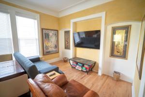 a living room with a couch and a flat screen tv at City Villa Sleeps 10-20 Free TV & Parking in Chicago