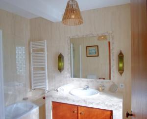 a bathroom with a sink and a mirror and a tub at Sonhos Cósmicos in Barril de Alva