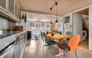 Pet Friendly Home In Thyholm With Kitchen في Thyholm: مطبخ وغرفة طعام مع طاولة وكراسي