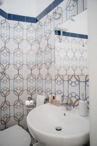ein Badezimmer mit einem weißen Waschbecken und einer Toilette in der Unterkunft Il Cortile by Vista Napoli in Neapel + 58 Fotos