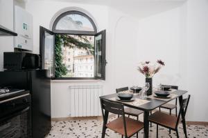 kuchnia ze stołem z krzesłami i oknem w obiekcie Il Cortile by Vista Napoli w mieście Napoli