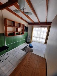 a room with a bed and a table and a window at Habitaciones en pensión en centro de Iquique in Iquique