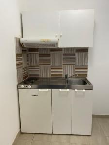 a kitchen with white cabinets and a sink at Villa Loukas in Loutsa