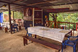 Hostal Caño Nevera في La Macarena: طاولة وكراسي في منزل مع طاولة وعلامة