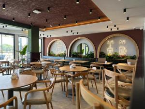 un restaurante con mesas, sillas y ventanas en Mrt Suites Lara, en Antalya