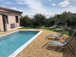einen Hinterhof mit Pool und 2 Stühlen in der Unterkunft Villa l'Amoureuse 3 in Saint-Paul-le-Jeune