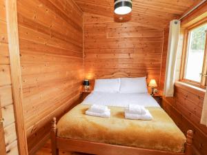 a bedroom with a bed in a log cabin at Snowdon Vista Cabin in Caernarfon