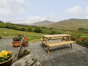 a wooden picnic table sitting on top of a hill at Snowdon Vista Cabin in Caernarfon