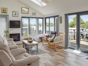 a living room with a couch and chairs and a tv at Evening Glory in Brundall