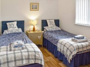 a bedroom with two beds and a table with a lamp at Evening Glory in Brundall