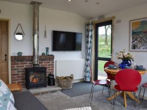Osprey Lodge في Westward: غرفة معيشة بها موقد وطاولة وكراسي