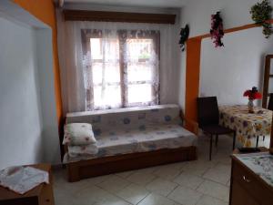a room with a window with a bench and a table at Akis Apartments in Mariaí